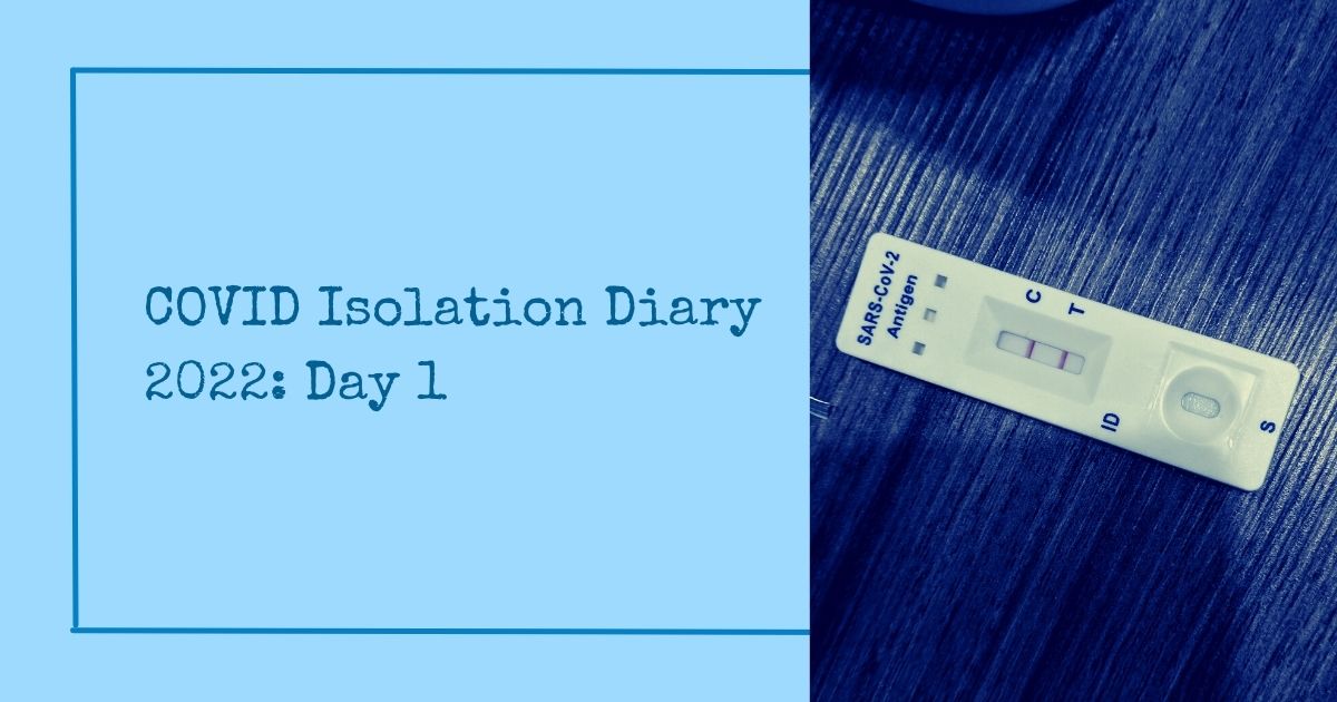 A dark-blue monospaced text saying "COVID Isolation Diary 2022: Day 1". There is a picture of a positive COVID at-home AntiGen test. It is mine. It has a blue filter on it. The background is light-blue
